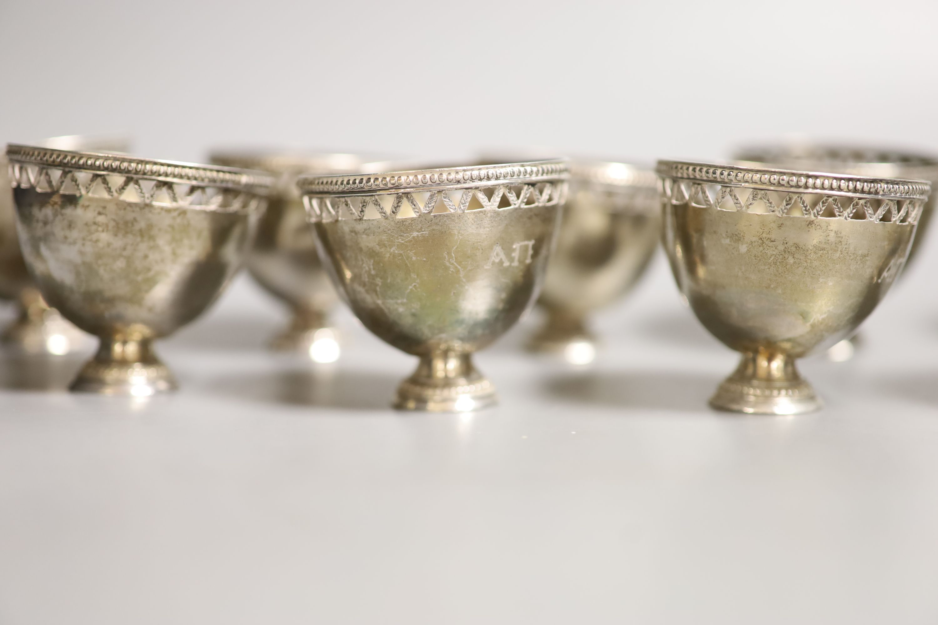 A set of twelve pierced small white metal footed cups